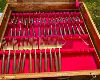 Lot 2175. $195.00. Vintage Brass with Rosewood Handled Flatware. 12 place settings; each setting has 11 pieces which include a steak knife, there are 12 additional serving pieces for a total of 144pcs. There is a storage box that is in rough shape but contains a storage area & covered drawer. Possible old Thailand/Siam flatware, not marked.