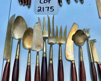 Lot 2175. $195.00. Vintage Brass with Rosewood Handled Flatware. 12 place settings; each setting has 11 pieces which include a steak knife, there are 12 additional serving pieces for a total of 144pcs. There is a storage box that is in rough shape but contains a storage area & covered drawer. Possible old Thailand/Siam flatware, not marked.