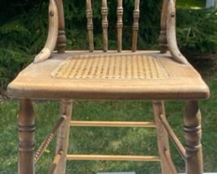 Lot 2196 $25.00 Vintage Cane Chair with Spindle Back and Carved Wood on Back of Seat Great condition! The scale of this chair is narrow and a little small, but high, sorry we don't have measurements for you!