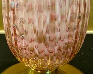 Lot 2140. Firm: $1,100.00. Handblown Murano MCM/Hollywood Regency Lamp. Ribbed Glass. Glass is pink with an underlay of cranberry and gold. Lamp tested. We didn't have a shade that paired well with this lamp. It is STUNNING. The homeowner got this lamp from her Aunt, who had it in the 50's. 35 1/2" to top of Finial x 7.5" brass base. There are two slight imperfections in the ribbing, barely noticeable. One feels as though it was part of the making process and the other one may have been a small ding that looks like it was professionally smoothed. Online a pair of these lamps have fetched $6,800 and similar versions of singleton lamps have sold for $3,500. Truly magnificent!