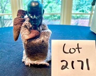 Lot 2171, $45.00. 5" African Ebony Wood carving of a man squatting wrapped in a blanket, holding an arrow quiver or drinking vessel. Signed, "MUZA" Kenya?