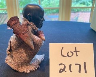 Lot 2171, $45.00. 5" African Ebony Wood carving of a man squatting wrapped in a blanket, holding an arrow quiver or drinking vessel. Signed, "MUZA" Kenya?