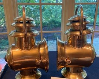 Lot 2249. $80.00. 2 Brass Railroad Signal Lamps. At first we thought these might be auto headlights for an early Model T, but they do have a red light on one side, and then a headlamp on the main side, and the glass cover swings open to reach the burner inside. The top is the chimney. The glass cover is broken on the right lamp, which shouldn't be hard to replace - and everything else appears to be in good shape.