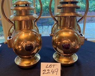 Lot 2249. $80.00. 2 Brass Railroad Signal Lamps. At first we thought these might be auto headlights for an early Model T, but they do have a red light on one side, and then a headlamp on the main side, and the glass cover swings open to reach the burner inside. The top is the chimney. The glass cover is broken on the right lamp, which shouldn't be hard to replace - and everything else appears to be in good shape.