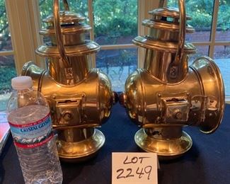 Lot 2249. $80.00. 2 Brass Railroad Signal Lamps. At first we thought these might be auto headlights for an early Model T, but they do have a red light on one side, and then a headlamp on the main side, and the glass cover swings open to reach the burner inside. The top is the chimney. The glass cover is broken on the right lamp, which shouldn't be hard to replace - and everything else appears to be in good shape.