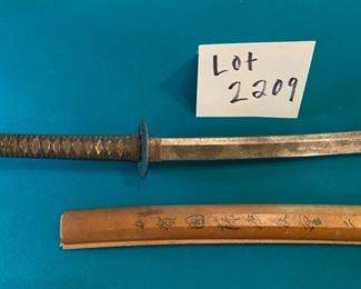 Lot 2209. $125.00 Very old Authentic Samurai Katana Sword. With leather-wrapped handle, Brass? inserts on the handle. Blade shows age. The wooden sheath is split has Japanese characters on it.