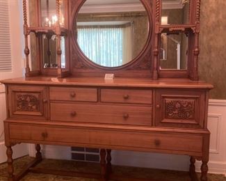 Lot 2265. $995.00. Unique Antique Buffet /Server and an open style mirror and shelving piece atop the buffet, with turned wood and interesting adornment. The two pieces coordinate, but are not an exact match, however, this was how the owners used these pieces. Selling as one lot. 4 drawers (2 w/liners for silverware) and 2 cubbies with beautiful carved front doors. "Buffet & Upper: Overall Height: 81""tall
Buffet: 66""w x 22""d x 37.25""
Upper: 43.5""h x 62""wx10.5""d. Mirror is 28.5 dia". Idea: The bottom half of this credenza could be used to hold a flat screen television, or of course as a buffet in a dining room, a foyer piece for storing gloves and hats or dog items, a bedroom as additional storage. Don't let the top piece (which is gorgeous) throw you off as to where you might use this! It's very functional in addition to beautiful.