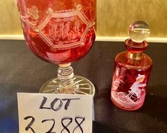 Lot 2288. $85.00 1) Cut to clear cranberry pedestal dish etched, 9" x 6" . 2) Cranberry Perfume Bottle with stopper hand painted, featuring a boy on a bicycle. 7" x 3.5". (Homeowner paid $110.00 for just the Perfume Bottle)