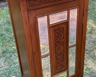 Lot 2304 $165.00 Mirrored, 4 shelf storage cabinet. Beveled mirrors on cabinet front with carved wood inlay. No key or knob 22" x 36.5"t x 16"d