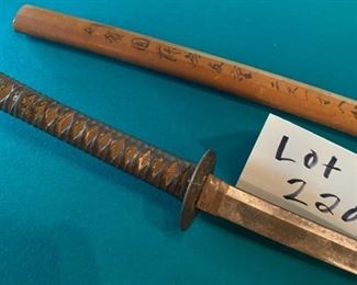 Lot 2209. $125.00 Very old Authentic Samurai Katana Sword. With leather-wrapped handle, Brass? inserts on the handle. Blade shows age. The wooden sheath is split has Japanese characters on it.