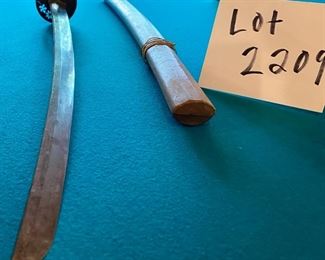 Lot 2209. $125.00 Very old Authentic Samurai Katana Sword. With leather-wrapped handle, Brass? inserts on the handle. Blade shows age. The wooden sheath is split has Japanese characters on it.