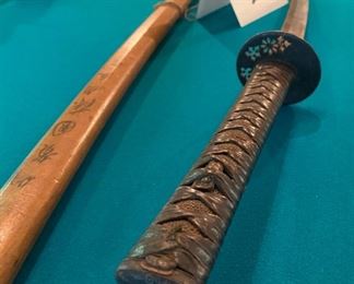 Lot 2209. $125.00 Very old Authentic Samurai Katana Sword. With leather-wrapped handle, Brass? inserts on the handle. Blade shows age. The wooden sheath is split has Japanese characters on it.