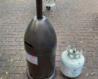 Lot 2314 $125.00 AZ Patio Propane gas heater. 41,000 BTU includes 1 FULL propane tank. The top Cover of the Heater is slightly bent, as shown in photo. We think it looks like a guy tipping his cowboy hat, and we like it!