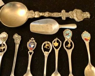 Lot 2401. 9 souvenir spoons, 1 pewter scooper, 1 small W. Germany scooper, Mt. St. Helens Ash, Sharps Creedmore in lucite and flower in lucite. Plus 2 antique sterling place card holders.