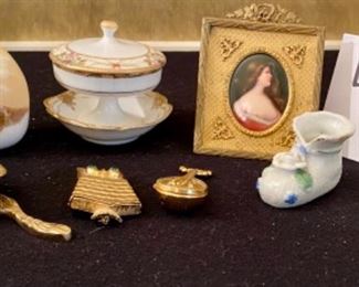 Lot 2410. $65.00. 8 pc Lot featuring: Fox Door Knocker (brass), Antique mini nude (painted on the ceramic), Nippon china footed trinket dish and small bowl, cool marble egg, and ceramic baby shoe, Brass Owl Pin, and Brass Lute Pill Hinged Box.