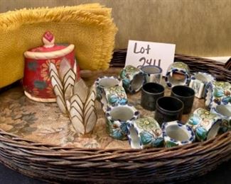 Lot 2411. $55.00. Vintage Wicker Tray with embroidery under glass (Some damage on one handle, 20"x13"), Mustard Napkins w/holder, 8 vintage place card holders (vintage flowers w/glass inserts), 12 napkin rings (signed mexican ceramics), 3 pewter or bronze napkin rings.