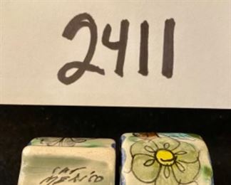 Lot 2411. $55.00. Vintage Wicker Tray with embroidery under glass (Some damage on one handle, 20"x13"), Mustard Napkins w/holder, 8 vintage place card holders (vintage flowers w/glass inserts), 12 napkin rings (signed mexican ceramics), 3 pewter or bronze napkin rings.