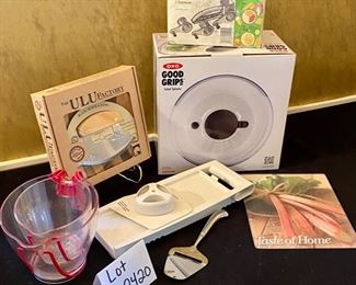 Lot 2420. $54.00. 2 measuring cups, taste of home glass trivet, cheese slicer, Vintage (like new), Moulinex multi-grater, New Ulu Factory chopper blade, block and bowl, OXO Good Grips Salad Spinner (in box), 4 papered chef food chopper with multiple attachments.