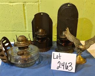 Lot 2463. $55.00. 3 vintage wall sconces (we have clear chimneys for these 3) oil lamps. 2 vintage amber glass handy oil lamp w/ reflector, hangs on the wall. And one brass eagle.