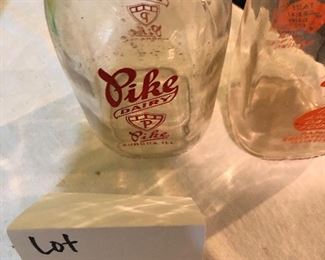 Lot 2464. $65.00. Vintage Bottles (8 pc) and vintage marbles. Lot Includes: Pike Dairy Cream Top with spoon bottle, 2 milk carafes, 1 green glass hinged bottle, 2 ball jars (1 with lid),