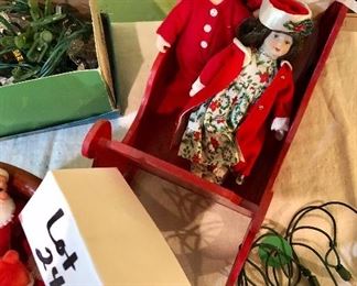 Lot 2487. $160.00. A huge lot of vintage Christmas. Includes a basket filled with vintage flocked Christmas light covers (a Radiant Decorative Light booklet), a Christmas Basket, 2 Gorham Christmas Dolls, one smaller Porcelain doll, a red sled, 2 vintage stands of lights (1 has a few glass snowflakes).