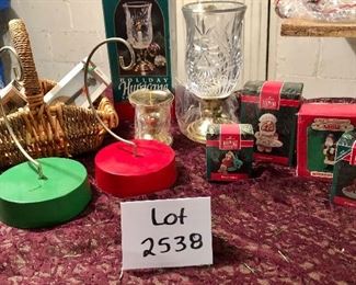 Lot 2538. $35.00. Mixture of a red and green music box/ornament holders, 4 Hallmark Keepsake ornaments in their boxes, one leaded crystal Hurricane Lamp for a candle in original box, another candle holder, and a basket with 3 cute cheap ornaments in boxes.