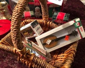 Lot 2538. $35.00. Mixture of a red and green music box/ornament holders, 4 Hallmark Keepsake ornaments in their boxes, one leaded crystal Hurricane Lamp for a candle in original box, another candle holder, and a basket with 3 cute cheap ornaments in boxes. Nice lot.