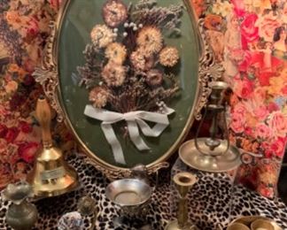 Vintage Bubble Glass Frame with dried Bouquet, Silver tone Penguin Trinket holder by Restoration Hardware, brass candlesticks, brass bell, crystal globe with brass axis holder and brass fluted edge vase, etc.