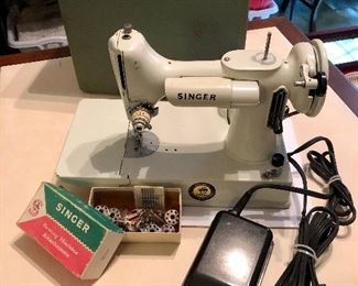 Vintage white Singer Featherweight 221K. The 221K Featherweight is the most wanted sewing machine ever built by the Singer Sewing Machine Company due to its light weight construction, compactness, and high versatility. Relatively few white machines were made, adding to their desirability and collectibility. Produced in 1964 in Kilbowie Scotland.
