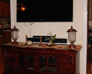 Large screen TV and cabinet below with electronics