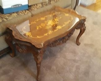 Nice inlayed wood detail on this french provincial  influenced  table with glass top protection 