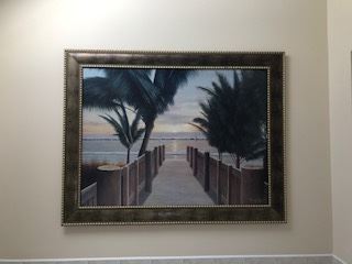 Costal scene wall art with ocean boardwalk palm trees  in brown wood frame with gold accent (57" length by 44" in height)  $50