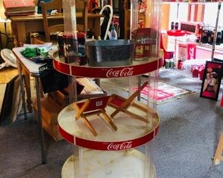 
This is a vintage 50 1/4" in height display rack for your Coca-Cola/Coke collectibles. Each shelf measures 22" in diameter. It is signed Paul Flum Ideals "FULL ROUND SHOWOFF IV" St. Louis, MO. The painted COKE/COCA-COLA printed red surface is for the m