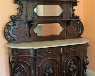 Marble Top Sideboard (Attributed to "Mitchell and Rammelsburg ") with mirrored top and Heavily Carved Fruits, Fish & Foliage.  In Pristine Condition Mahogany  Measures 97" tall, 72" wide and 26" deep 