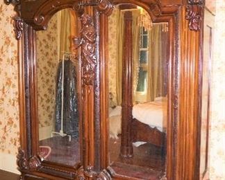 Monumental Heavily Carved Italian Baroque Mahogany Two Door Armoire with lower single drawer.  Solid Carved full body Italian Maiden, Open Pierced Carved Crown and Original Urn Finials. on Carved Feathered Feet  Measures 110" tall, 80" wide & 25" deep.