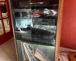 Vintage turntable, records, stereo system in cabinet