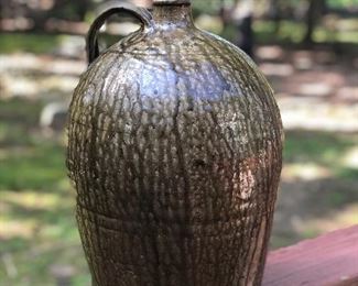 Lot 1: Edgefield Ovoid Jug, 3 Gall, some chipping on rim and a raw-exposed pottery indentation on side from either damage or a lean-to mark during making (see photos), No cracks; Markings: Two straight hash marks at bottom/body of the jar; Measuring 13" tall, 10" widest point. Purchase Price: $1,250.
