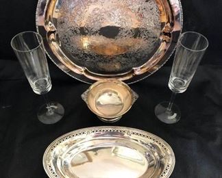 https://ctbids.com/#!/description/share/537439 Sterling Silver Tray and Champagne Flutes
Sterling oval tray with decorative perforated edge. Small footed sterling dish with elegant handles. Round Quadruple Plate Silver serving tray. 2 glass Martini & Rossi champagne flutes.