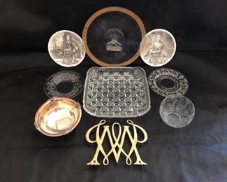 https://ctbids.com/#!/description/share/537443 William and Mary commemorative Wedgewood plates and gold toned trivet representing William and Mary College. Center handle glass serving platter with gold rim. Decorative etched glassware. Small silver footed bowl.