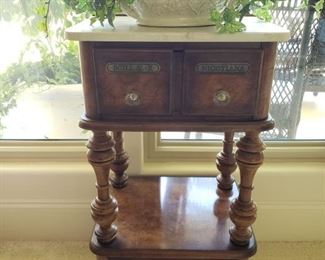 https://ctbids.com/#!/description/share/545543 Very unique piece that will add character to your home. *Reserve Price Set For $250* Apothecary side table with marble top and casters. Greenery is included. 14.5" deep. See photos for other measurements. “These tables were very popular in the late 1800's and early 1900's when home remedies (homeopathy) was popular. Nicotiana were drugs from various nicotine plants. Scill AE R were drugs derived from scillae plants."