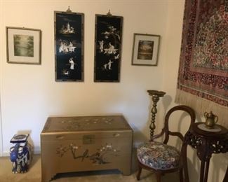 Beautiful gold trunk that is in pristine condition. Ceramic elephant , original watercolors, and lacquered panels. Brass plant stand, carved table with marble insert, ornate chair, and large hanging silk rug. 