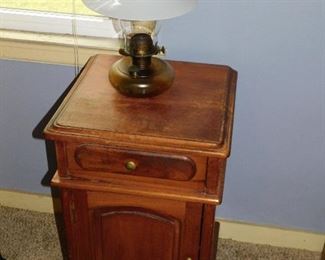 Small antique table, oil lamp with milk glass shade.