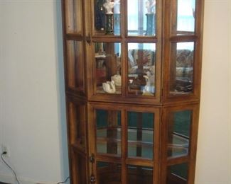 Living Room:  A lighted glass multi-panel/two section display cabinet has four glass shelves.  The upper and lower sections each have their own door.   It measures 45" wide x 16" deep x 68" tall.