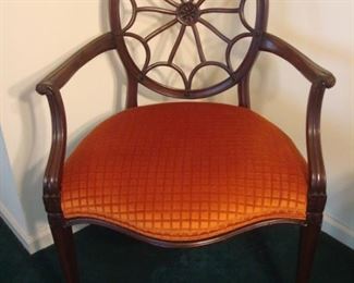 Living Room:  A classic spoke/web chair is upholstered in a vibrant melon color.