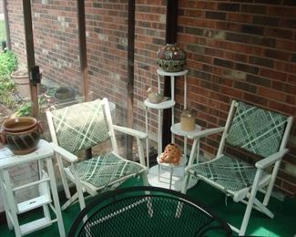 Sun Room:  A white "ladder/stand" is to the left of two individually priced white, wooden folding chairs with green chair pads and a multi-level wooden stand.  The pottery items shown are also for sale.