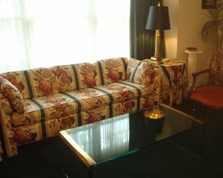 Living Room:  A custom upholstered floral sofa measures 83" long.  It has three detached back cushions, two side pillows, and one single bench cushion.  It is flanked by two tables with matching tablecloths (each item is separately priced).  Closer photos of the other items follow.