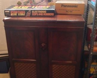 Lower Level:  Two games and a new PANASONIC radio are displayed on a vintage (already gutted) radio cabinet.