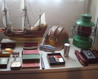 Lower Level:  Quite a collection of shaving items are shown among a ship, SVERDRUP & PARCEL hard hat, and a St. Louis lantern.