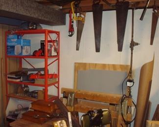 Lower Level-Tool Room:  Saws hang from the rafters but other tool-related items are on the metal shelf.