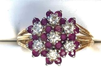 14KT white and yellow gold cast colored ruby and diamond cluster ring with a high polish finish. It has seven prong set round brilliant cut diamonds with an approximate total weight of seven stones equaling 0.50ct. It has 24 prong set round standard brilliant cut natural rubies with the total approx. weight of 1.20ct.